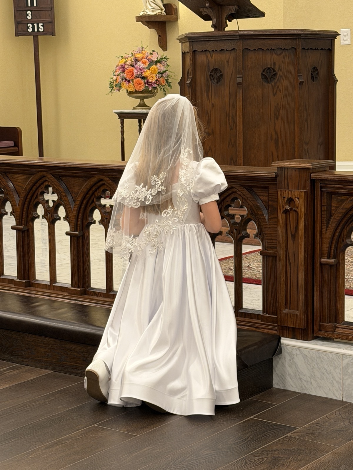 First communicant kneeling at the altar rail